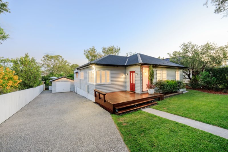 Classic brick home with red garage door, Western corridor suburb
